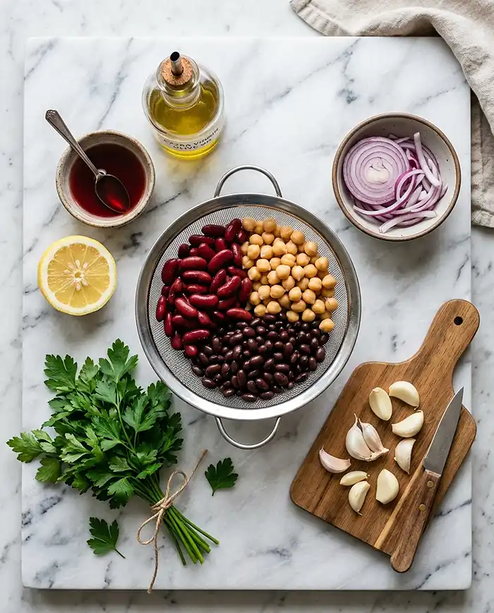 Dense Bean Salad Recipes 2 Key ingredients for dense bean salad including mixed beans, lemon, olive oil, red onion, and fresh herbs